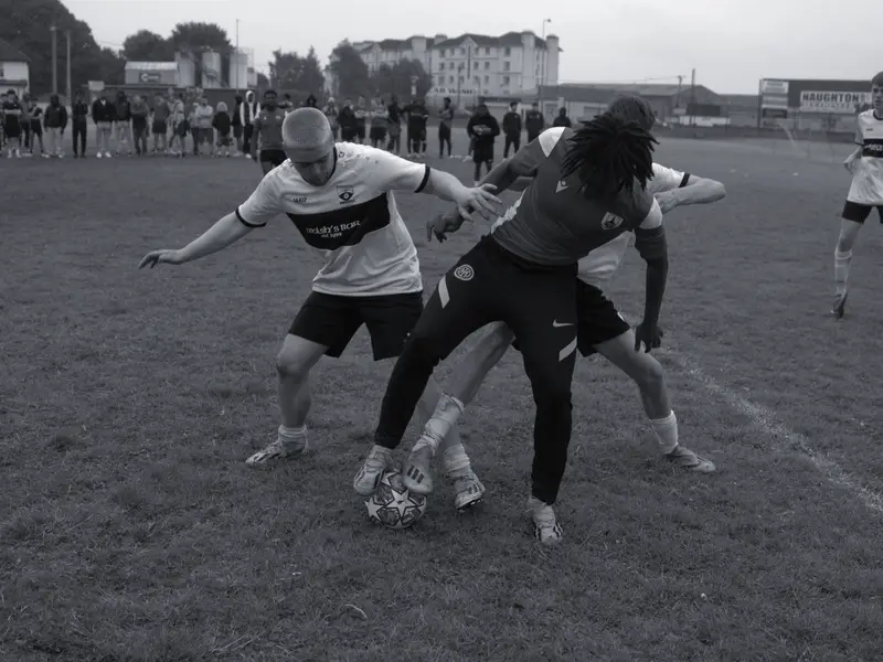 A player shields the ball from two defenders at the 2024 tournament